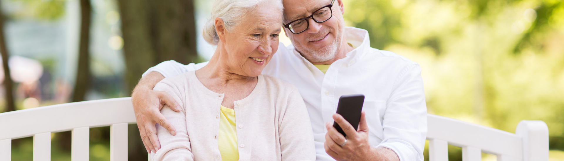 Zwei ältere Menschen gucken auf ein Handy