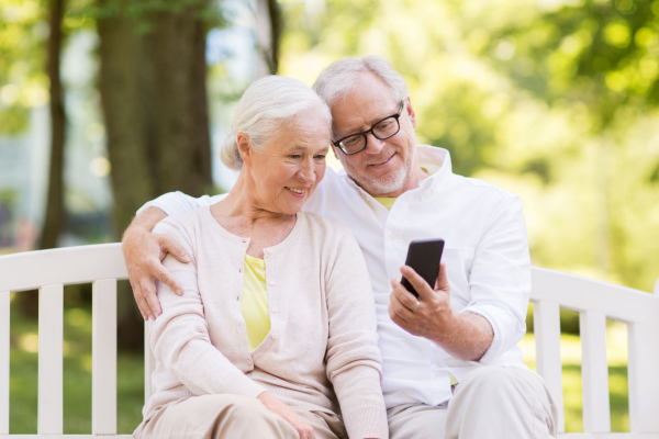 Zwei ältere Menschen gucken auf ein Handy